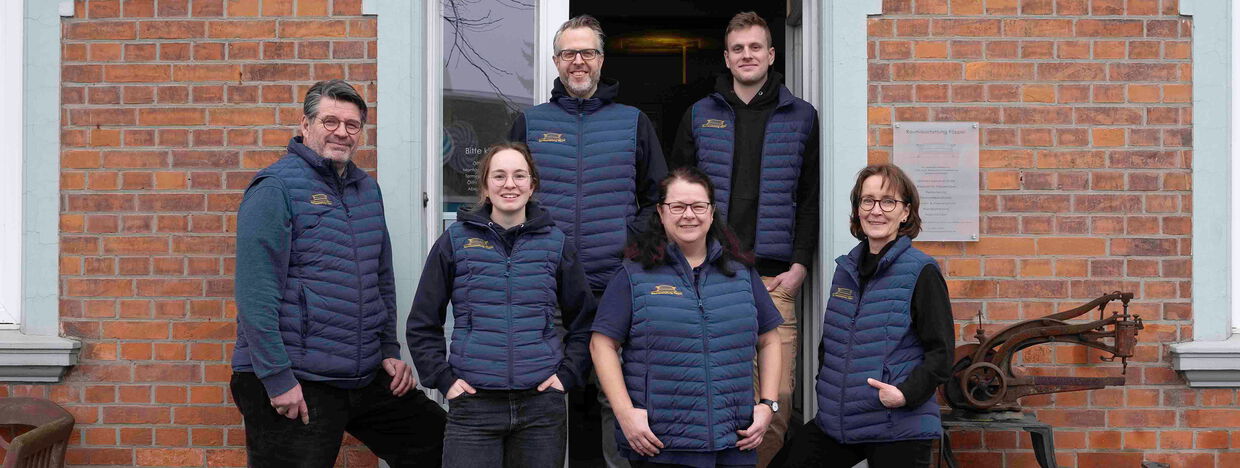 Das Team von Raumausstattung Pöppel steht vor dem Geschäft