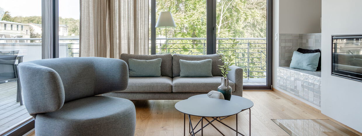 Wohnzimmer mit Sessel, Couch, Kamin, Tisch